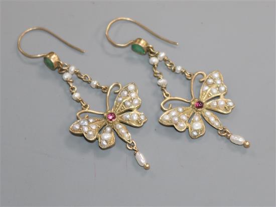 A pair of yellow metal, emerald, garnet and seed pearl set butterfly drop earrings, stamped 9ct, overall 51mm.